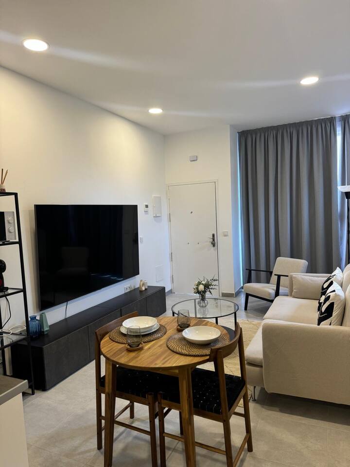 ממוקמת בקומת הקרקע בגובה הרחוב ומחוברת למטבח פתוח, חדר שינה וחדר רחצה. טלוויזיה חכמה עם מסך שטוח בסלון מול הספה ובחדר השינה. 