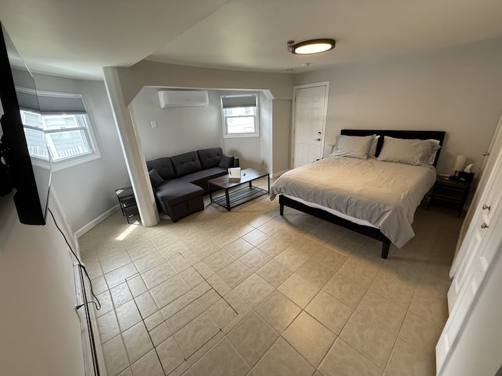 Descansa tranquilo en nuestra acogedora habitación, con una cama tamaño queen y estaciones de carga dedicadas junto a la cama para todos tus dispositivos.