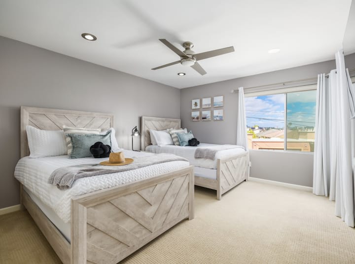 Ნათელი და პლაჟისპირა ორი მყუდრო საწოლი, სმარტ-ტელევიზორი და ფანჯრები, რომლებიც საცხოვრებელს ბუნებრივი განათებით ავსებს