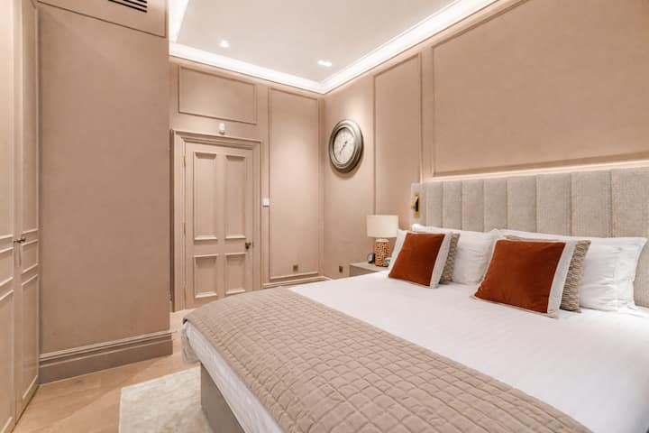 ห้องนอนที่สงบและได้รับการตกแต่งอย่างสวยงาม มีเตียงขนาดคิงไซส์พิเศษพร้อมผ้าปูที่นอนคุณภาพระดับโรงแรม หมอนอิงนุ่มและหัวเตียงบุผ้าตามสั่ง แสงไฟแอมเบียนท์อ่อนๆ และโทนสีโทนกลางอบอุ่นสร้างความสงบและหรูหรา เหมาะสำหรับการพักผ่อนอย่างเต็มที่