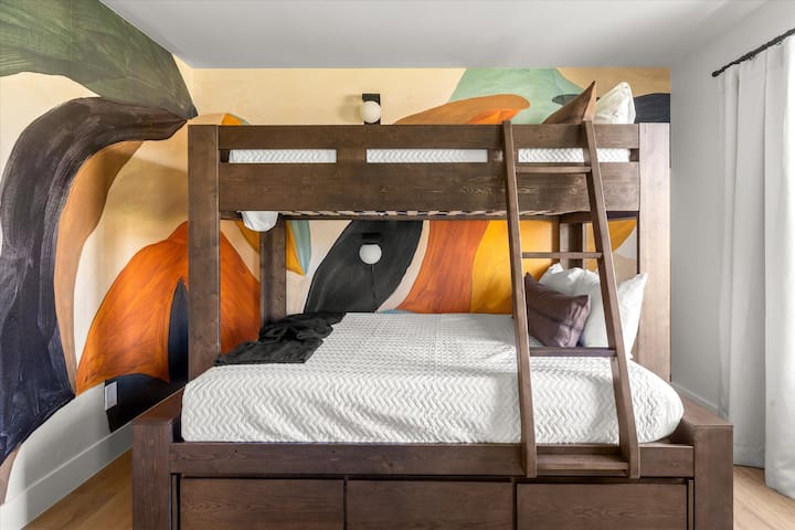 Táto izba má poschodovú posteľ s jednou posteľou na vrchu a jednou na spodku – pohodlnú samostatnú posteľ na vrchu a plnohodnotnú (manželskú) posteľ na spodku. 