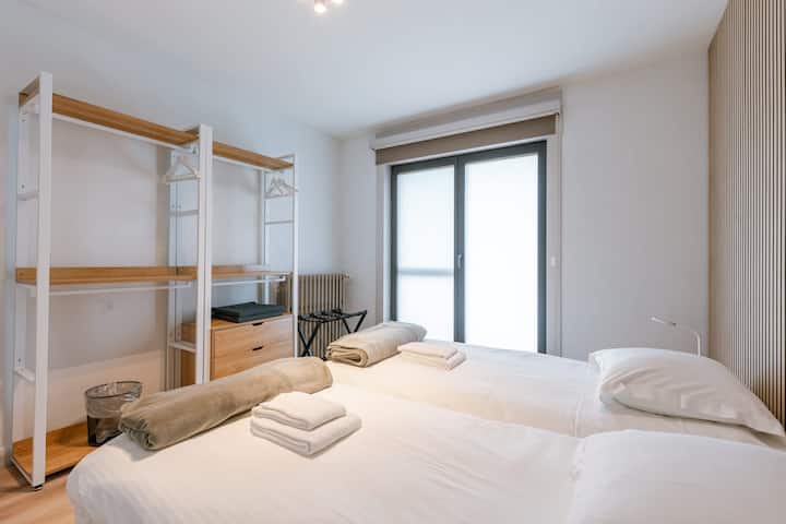 Уживајте во мирна ноќ во оваа пространа двокреветна соба со мека природна светлина, удобен декор и практично отворено складиште