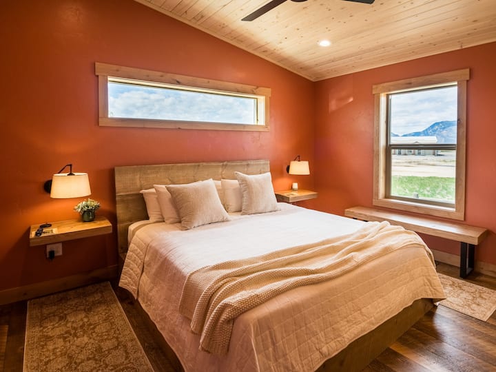 Спокојство во рамка од Сидар и Картер
Оваа топла брачна спална соба со поглед кон запад нуди одмор со своите богати ѕидови од теракота, меки текстури и слоевита светлина. Погледнете кон планината Сидар преку прозорецот со слики или ѕирнете ја планината Картер над 