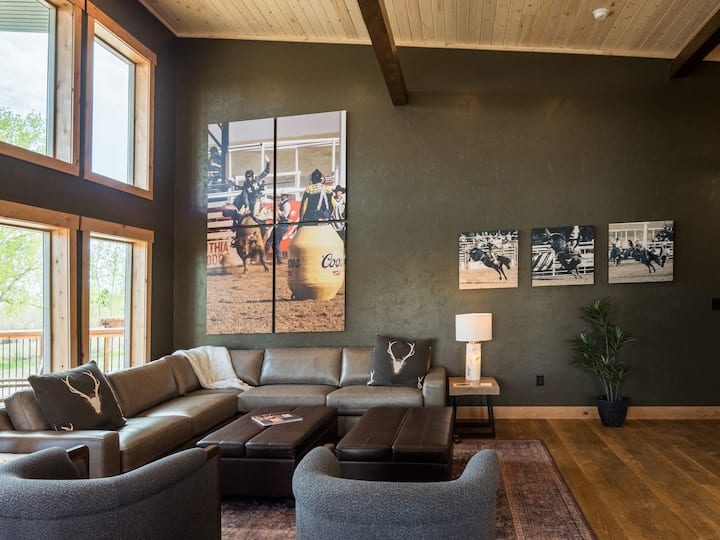 Каде што западното наследство се среќава со модерните комунални услуги
Впечатлив триптих со димензии 5'x 8' ја зацврстува дневната соба на западната колиба, прославувајќи го родеото на Коди во задебелен обем. Два големи отомани се трансформираат во двокреветни кревети кои го прават овој простор исто толку функционален колку што е