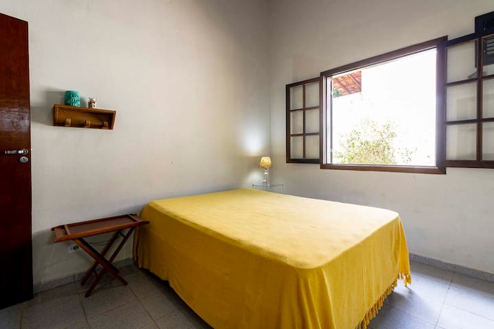 Junto a la cama doble de la suite 2, hay una mesita de noche con una lámpara