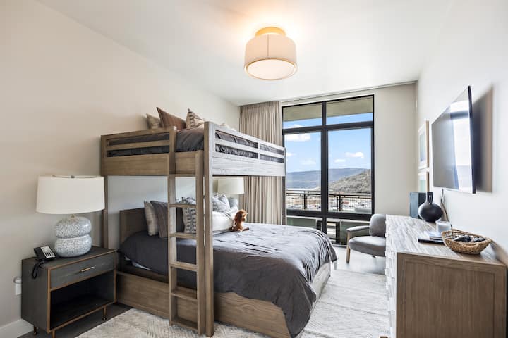 - Bedroom with twin over queen bunk bed and mountain view  
- Cozy layered bedding and soft lighting for a restful stay  
- Flat screen TV and dresser provide comfort and convenience