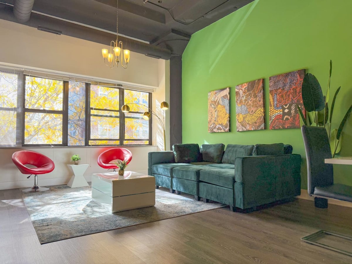 Prostrani dnevni boravak s puno prirodnog svjetla i velikim prozorima.