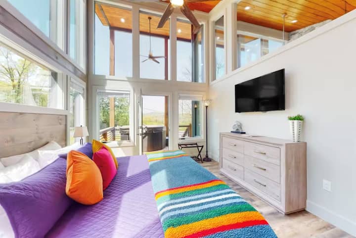Cómodo dormitorio con ventanas altas y televisor inteligente, ideal para noches de descanso durante tu escapada a Blue Ridge cerca de senderos y favoritos locales.
