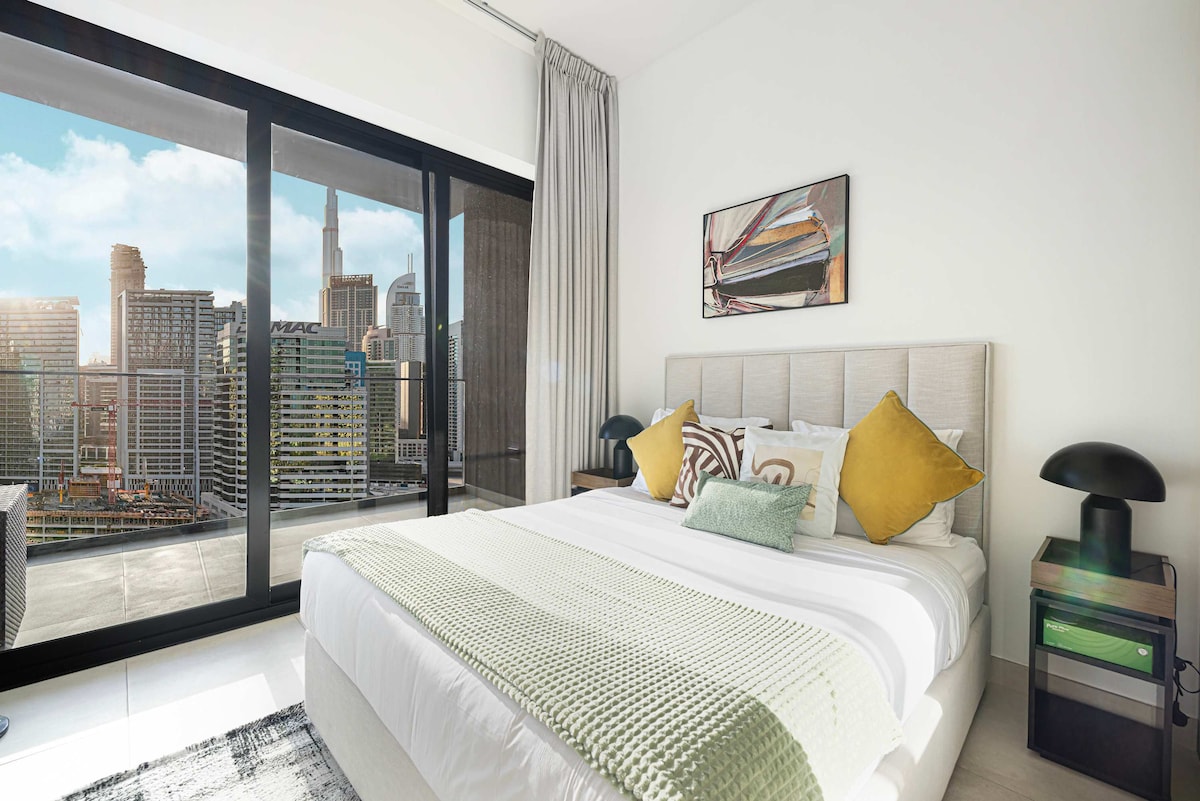 ادخل إلى غرفة النوم ذات الهواء الطلق مع سرير مريح وشرفة خاصة، مما يوفر إطلالات منعشة — ملاذ مثالي للاسترخاء والاستجمام.