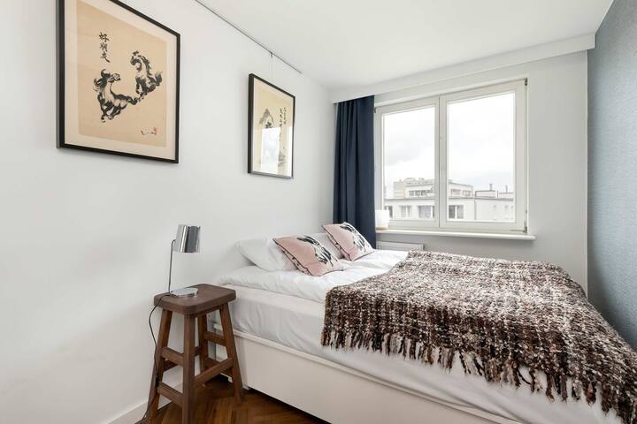 Dormitorio con colores suaves, ropa de cama acogedora y ventanas grandes.