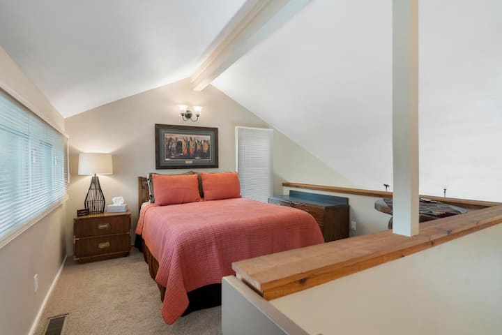 Cama tamaño queen en la zona abierta del loft  