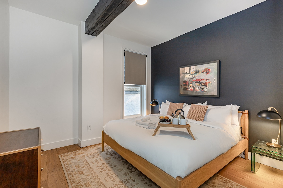 Ძირითადი საძინებელი დიდი საწოლით, დახვეწილი კედლით და მოსახერხებელი კარადათი.