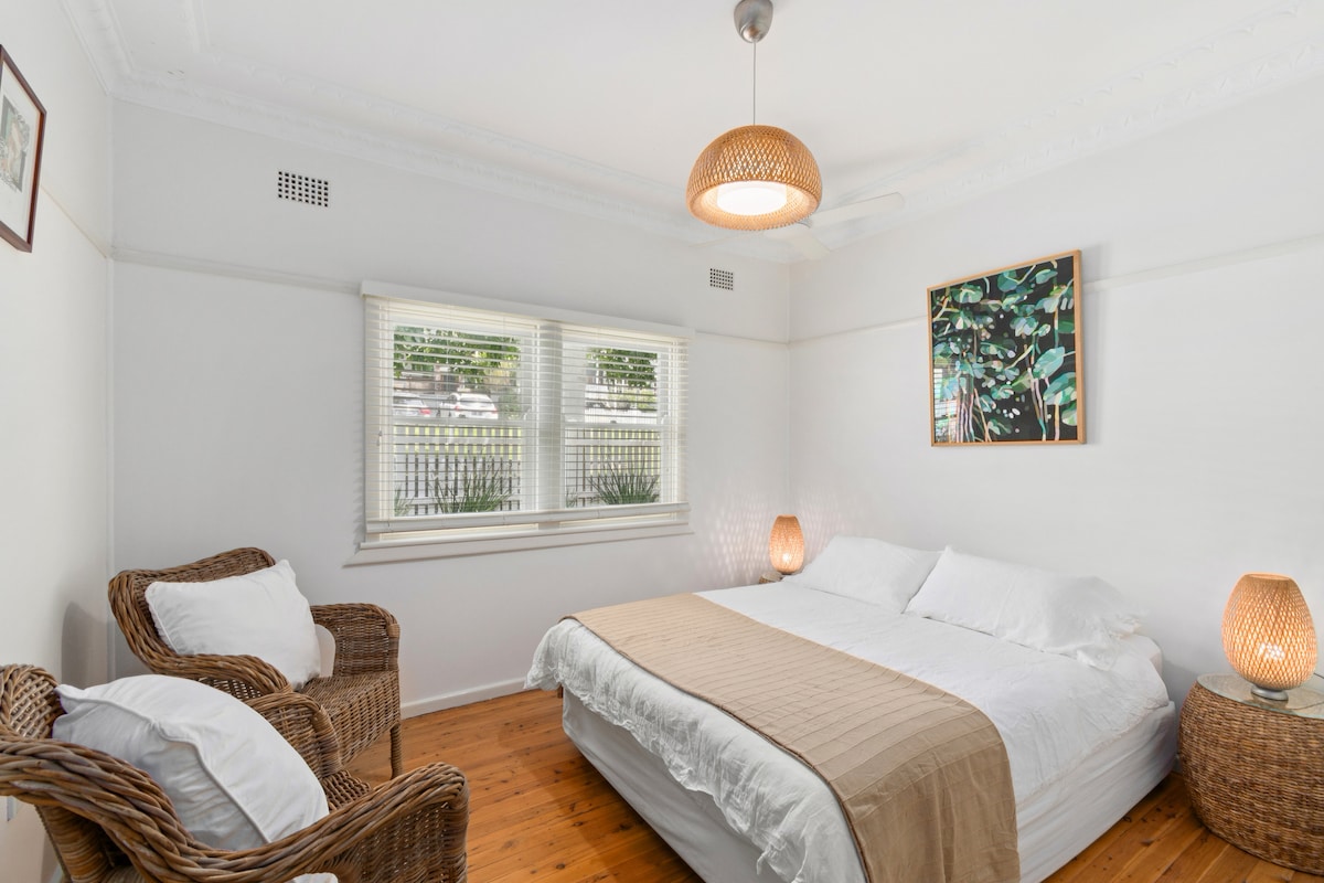 The primary bedroom offers a peaceful escape with a queen-sized bed and a reading nook, perfect for restful nights and slow mornings.