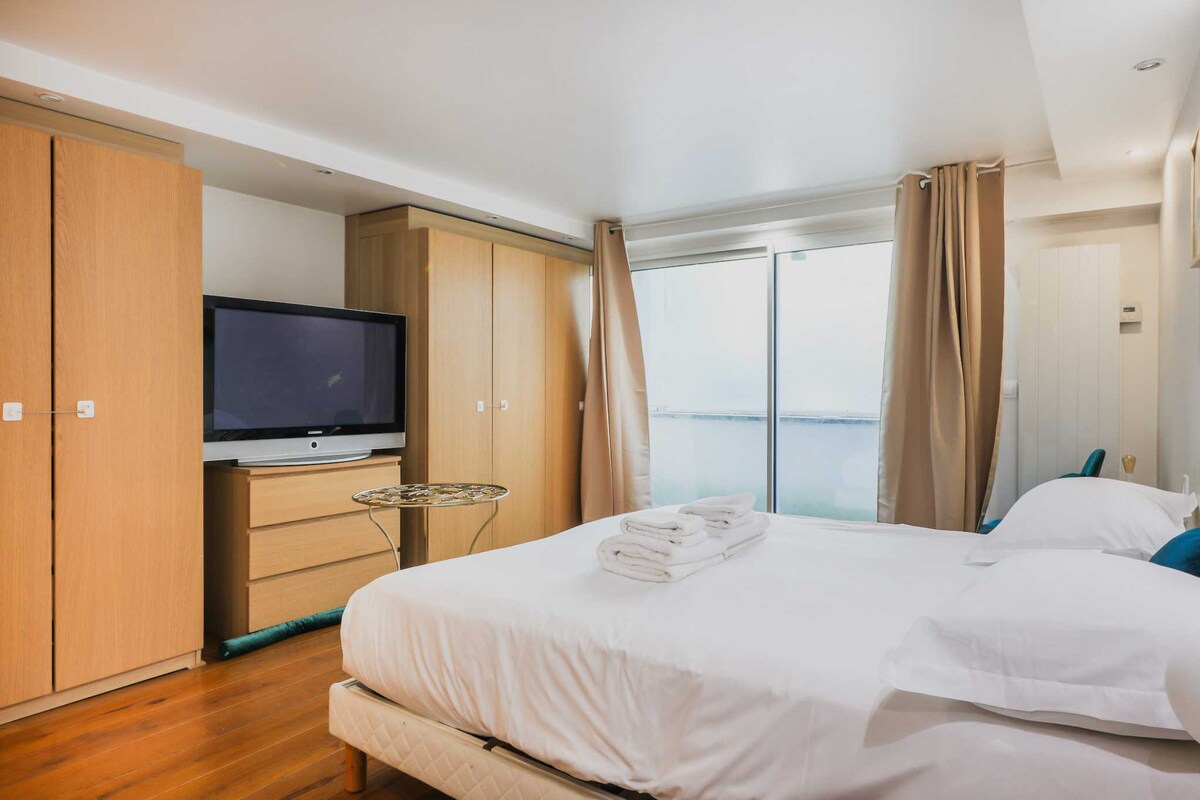 Una habitación con una cama King Size, un televisor y un armario. 