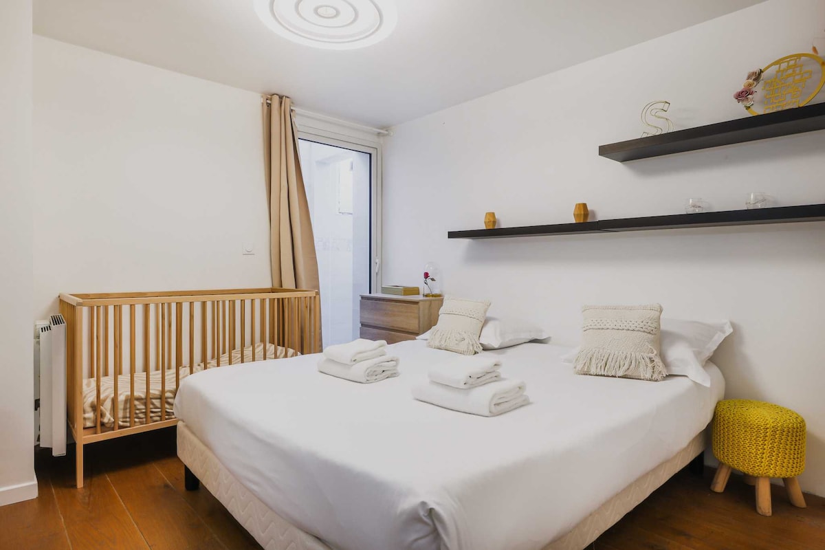 Una habitación con una cama Queen Size y una cuna 