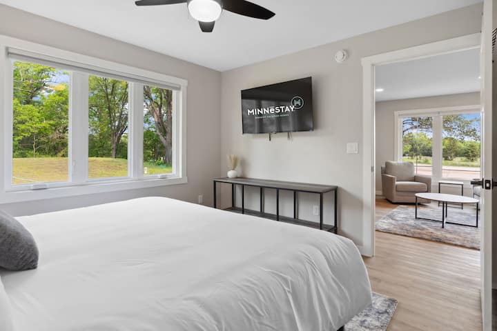 Drift off in your serene bedroom with natural light streaming through windows, modern TV entertainment, and a peaceful living area just steps away.