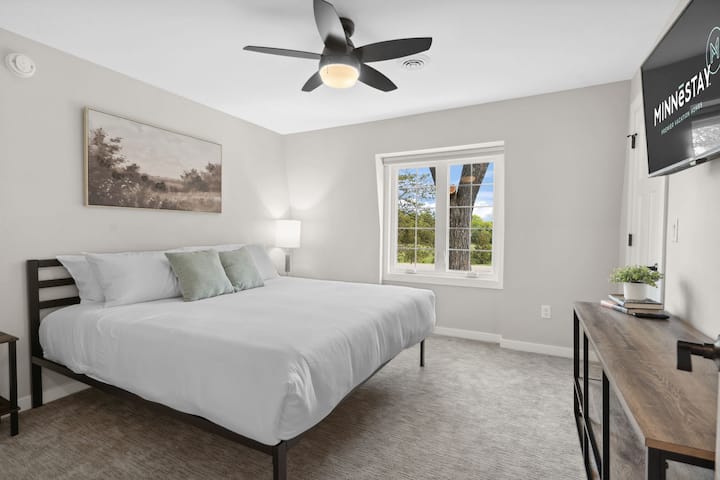 Sink into crisp white linens while enjoying tree-framed views from your peaceful bedroom retreat.