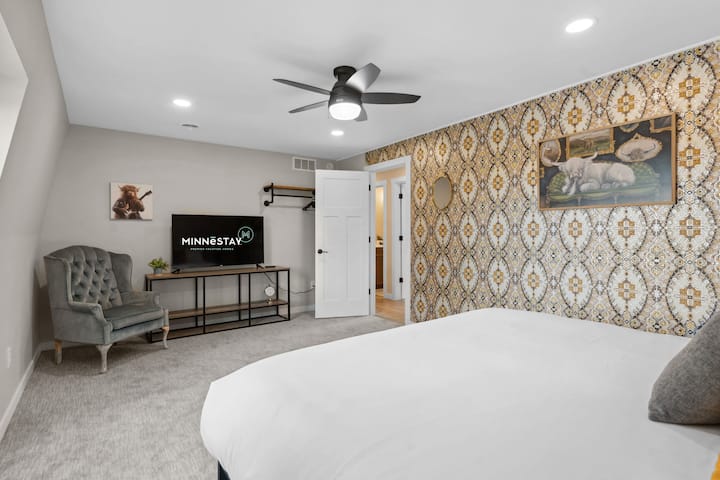 Your spacious bedroom combines comfort with style, featuring a statement wallpaper accent wall and modern amenities for ultimate relaxation.