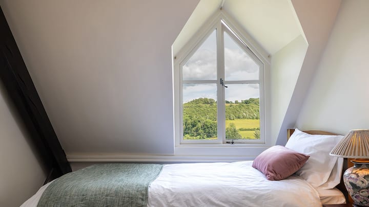 بالنظر عبر الوادي، تحتوي غرفة النوم الرابعة على سرير فردي مع خزانة أدراج صغيرة بجانب السرير