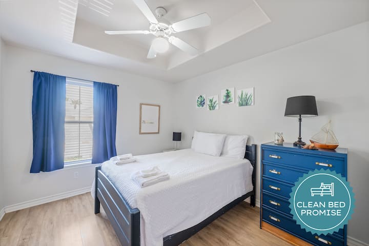 Relájese en esta tranquila habitación con sábanas limpias, decoración costera y ventilador de techo para disfrutar de una noche de sueño perfecta.