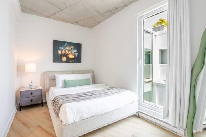 Cette chambre à coucher lumineuse avec un grand lit offre une escapade sereine, avec un design minimaliste et des accents naturels qui invitent à un sommeil paisible.