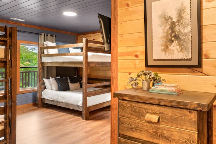 Amplia habitación con literas con dos camas tamaño queen, dos camas individuales, TV y baño privado.