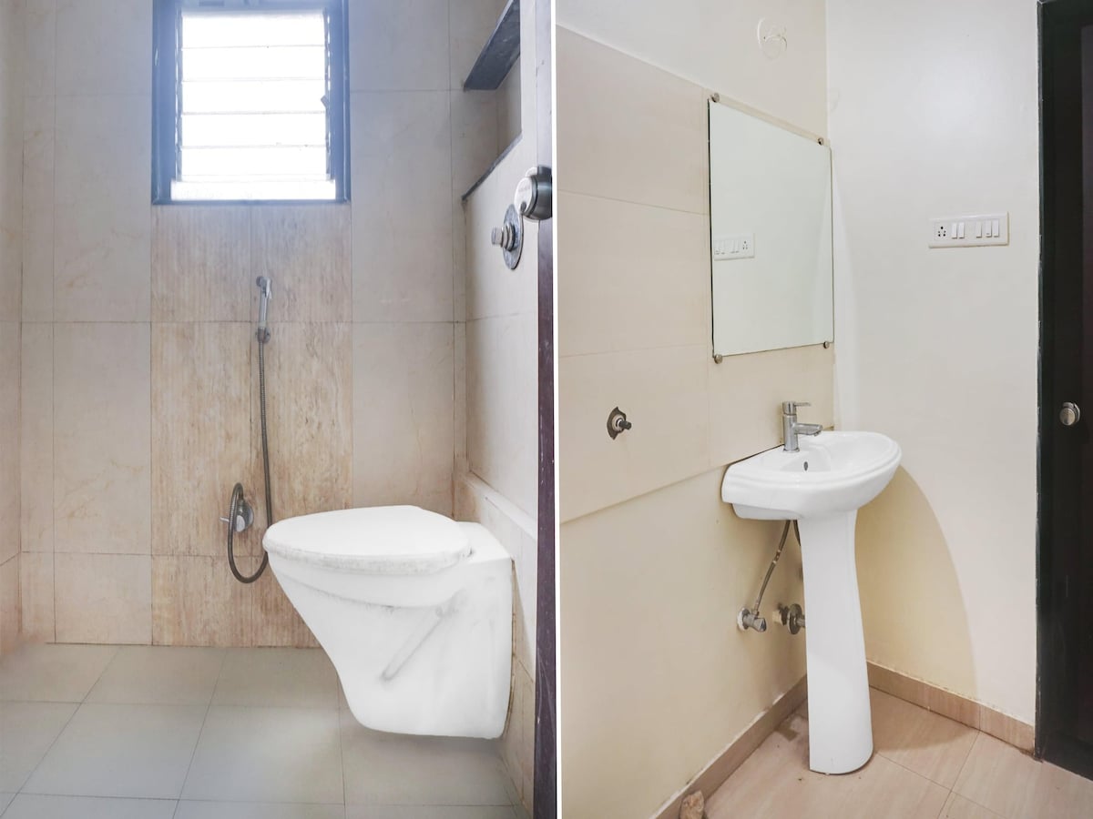 The image shows two bathroom areas featuring neutral-colored tiles. The left side displays a shower with a handheld fixture beside a modern toilet. The right side includes a pedestal sink with a mirror above, showcasing simple, functional designs in each space.