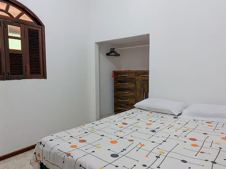 Chumba cha kulala chenye kitanda cha watu wawili, kabati na kiango cha kupangia nguo zako