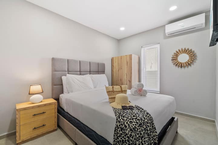 Dormitorio luminoso con muebles modernos y ropa de cama acogedora.