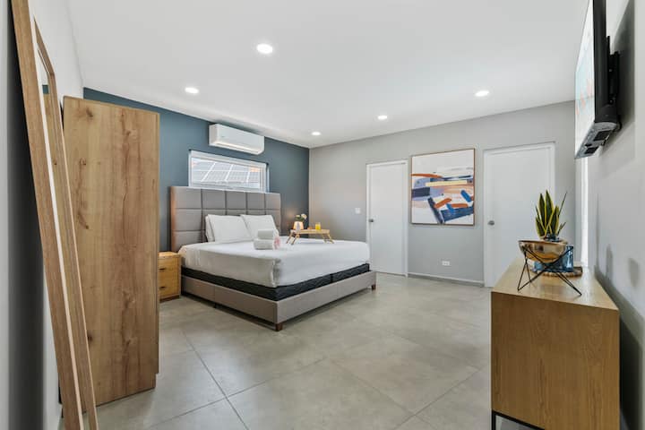 Dormitorio contemporáneo con una cama tamaño king y una iluminación acogedora.