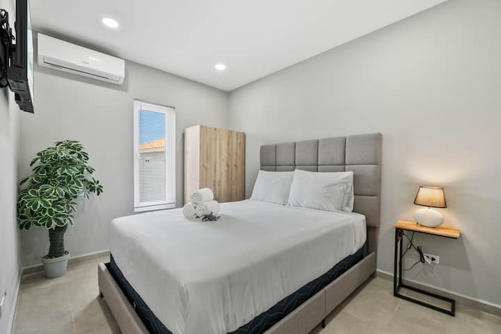 Dormitorio elegante con líneas limpias y luz natural.