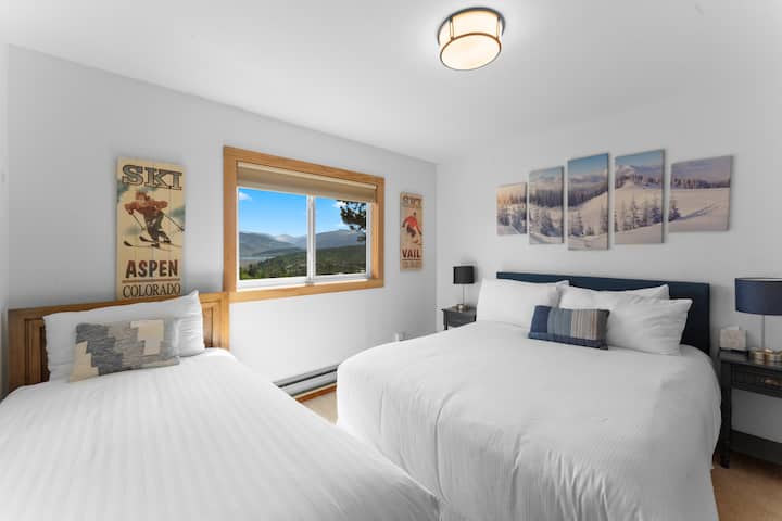 Upstairs guest bedroom featuring a queen bed, twin bed, and TV. 