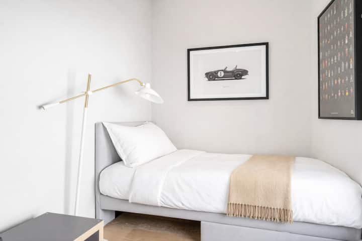 别致简约的卧室，配有舒适的单人床、精心挑选的艺术品和温暖的氛围照明，为客人提供安静、时尚的休憩之所，营造出精致精品酒店的感觉。