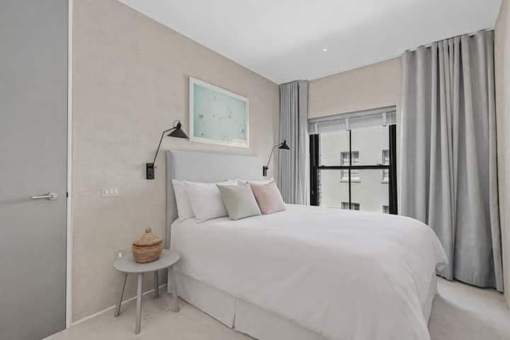 卧室布置精美，配有舒适的床、柔和的中性色调和柔和的自然光，为客人提供宁静优雅的空间，旨在打造舒适奢华的住宿体验。