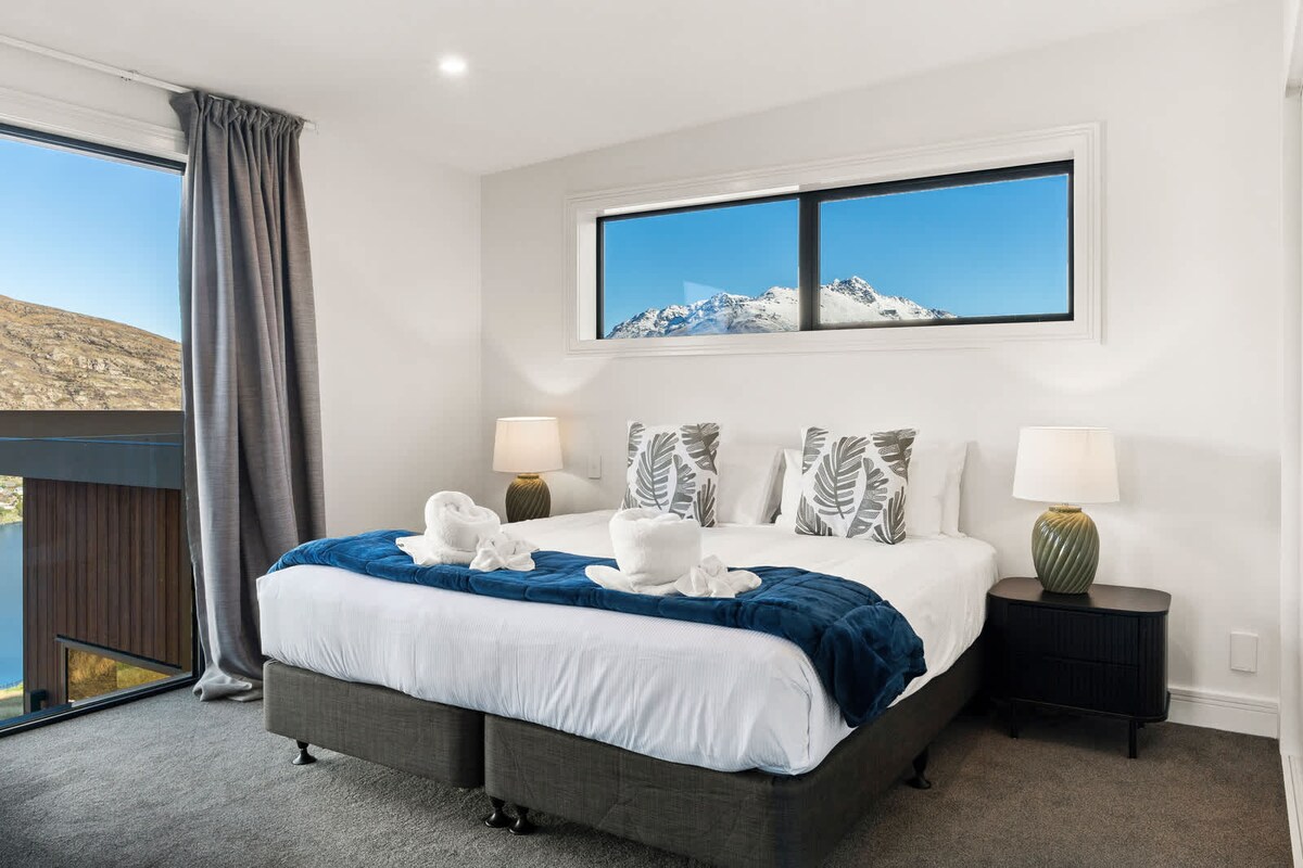 Chumba cha kulala chenye nafasi kubwa chenye madirisha yenye mwonekano wa pande mbili na mwonekano wa milima.