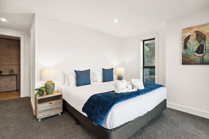 Простора спальня з ліжком розміру King size, оформлена в спокійних тонах і з розкішною обробкою.