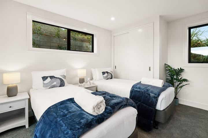 Затишна двомісна кімната з плюшевою постільною білизною та видом на сад.