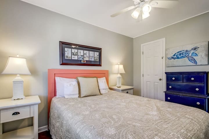 Espacio acogedor en el dormitorio con ropa de cama lujosa y toques costeros.