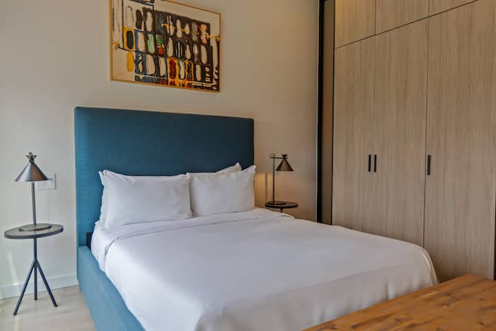 Dormitorio acogedor con luz natural y ropa de cama lujosa