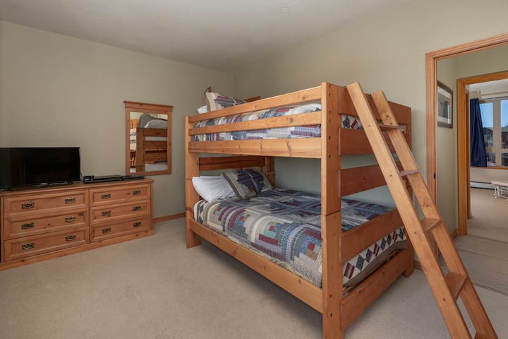 Dhomë e rehatshme me krevat marinari, e përkryer për fëmijë ose grupe, me mobilje druri të ngrohta dhe pajisje argëtimi për net të paharrueshme së bashku.