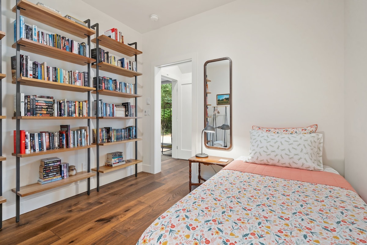 PADDEN kambarys, jaukus dvivietis miegamasis su meniniais akcentais ir vaizdu į namelį medyje.