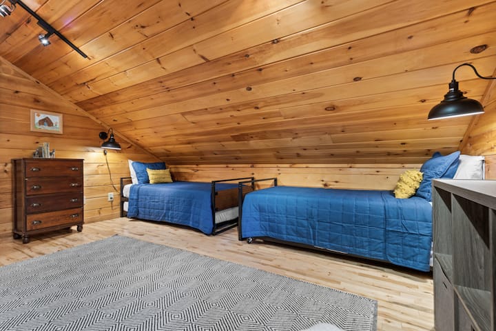 Шармантна спална соба на поткровје | Двокреветни кревети со удобна сина постелнина, дрвени плочи и тема за авантура „Продолжете да истражувате“