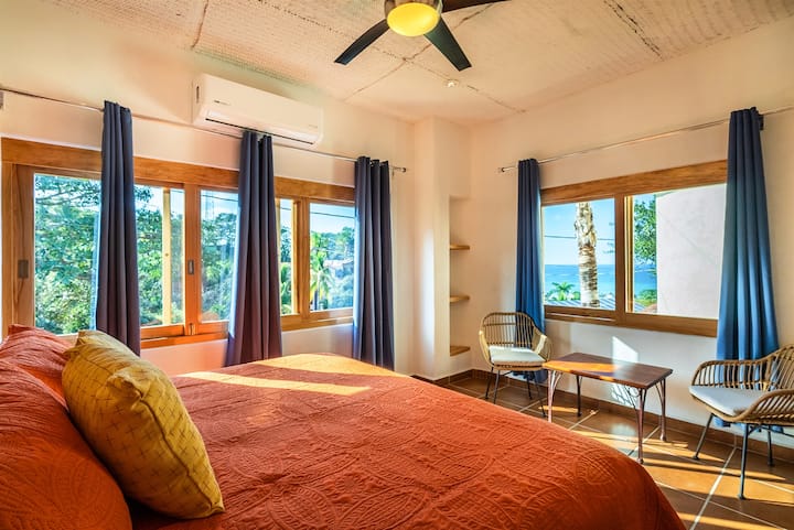 Светла спална соба со поглед кон џунглата и мека природна светлина