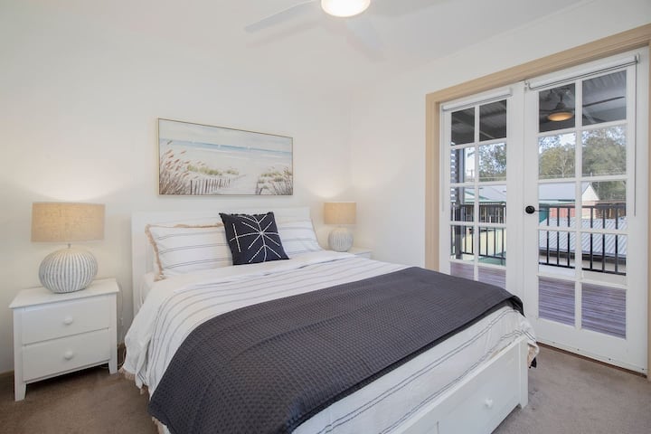 חדר השינה השני בקומה העליונה, המעוצב בסטייל עם מיטת קווין סייז מפנקת ויצירות אמנות חוף, מבטיח חלומות מתוקים ושלווה. חדר זה מציע גם גישה ישירה למרפסת.