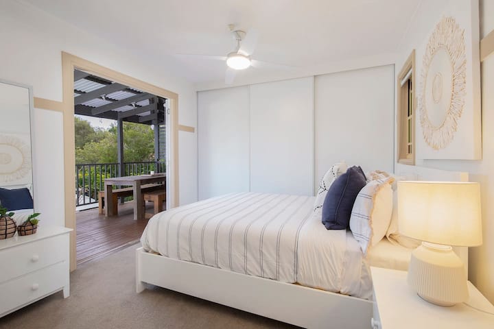 חדר השינה הראשי למעלה, שבו מיטת קווין סייז וגישה ישירה למרפסת פרטית מציעים שלווה ופרטיות.