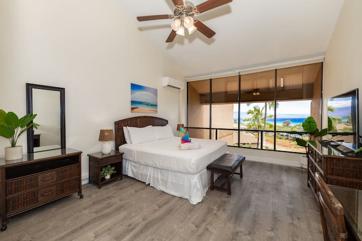 Разбудете се со неверојатен поглед кон океанот во оваа ветровита спална соба на Мауи, опремена со сводести тавани, вентилатор на таванот и декор инспириран од плажата - идеален за тропски одмор.