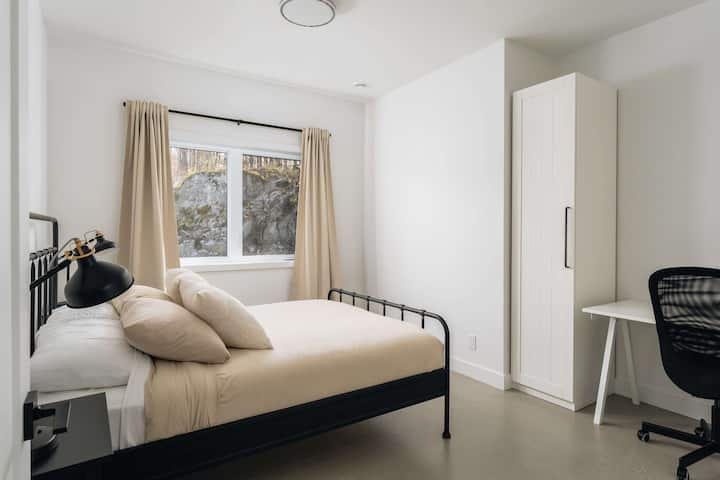 Moderna spavaća soba s bračnim krevetom i radnim stolom