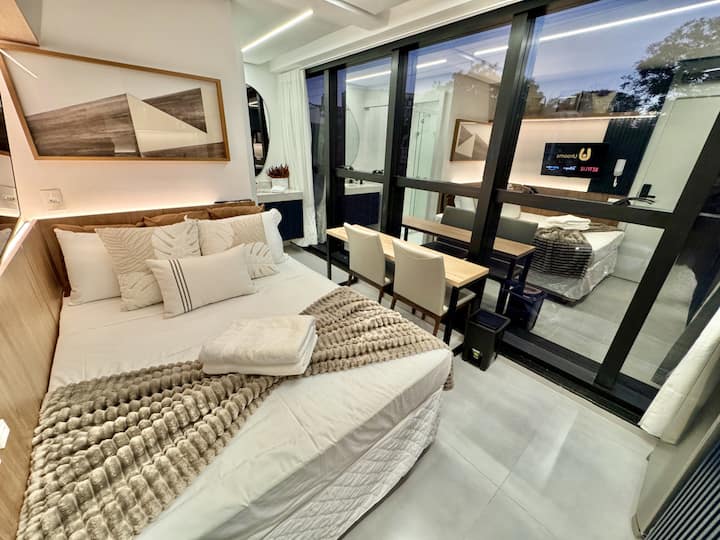 Bedroom seen from the entrance, with blackout curtains and a flat-screen TV