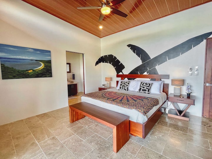 Chumba #1 kilicho na kitanda cha ukubwa wa kifalme, mandhari ya bahari, ufikiaji wa baraza, A/C, feni ya dari na bafu la chumba cha kulala. 