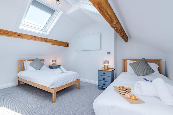 La chambre 3 est nichée dans un loft magnifiquement aménagé, avec deux lits simples et de charmantes poutres d'origine. Parfait pour les groupes ou les familles, il offre une ambiance chaleureuse et accueillante pour un séjour mémorable.
